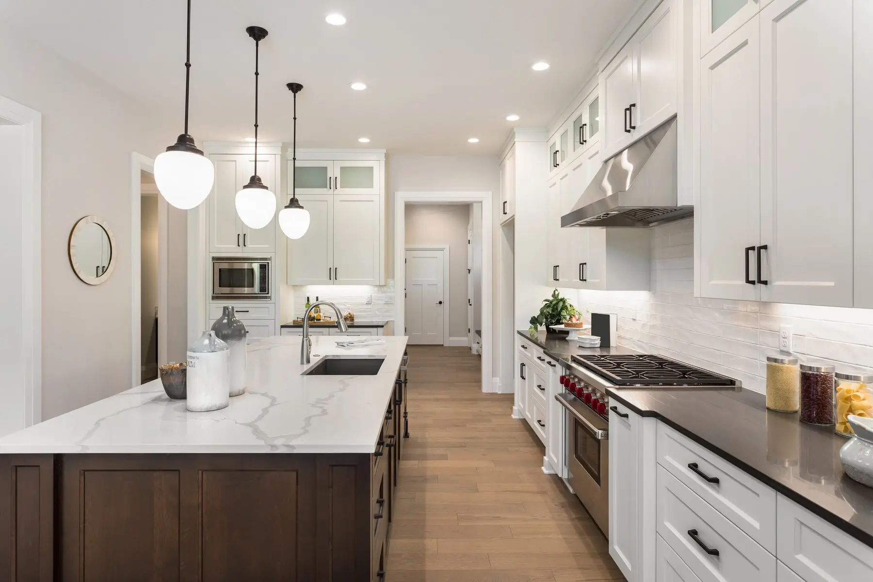 White shaker kitchen with pendant lights and timber floor, Finer Touch Projects